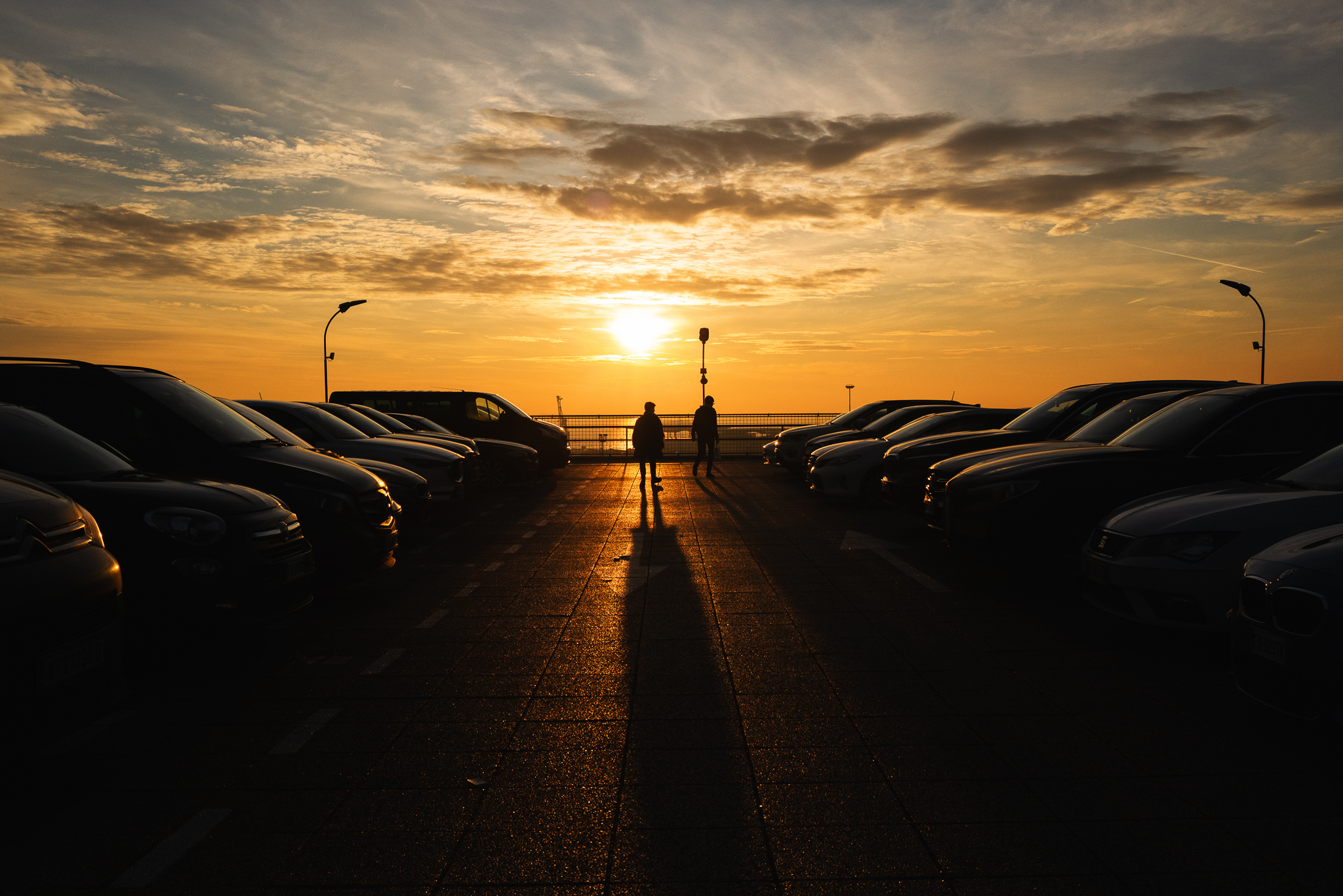 Sunset silhouettes on the parking garage rooftop.